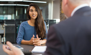 Menina em entrevista com recrutador. Imagem simboliza erros comuns em uma entrevista de emprego.