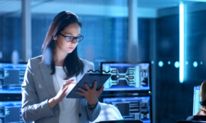 Profissional mulher mexendo em tablet. Imagem representa profissional de Segurança da Informação na empresa.