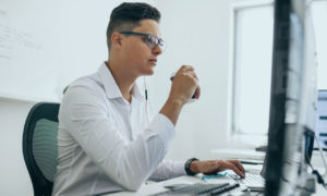 Homem em frente ao computador. Imagem simboliza que ele é um profissional de Devops.