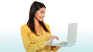 Mulher segurando notebook. Imagem simboliza que ela trabalha como Desenvolvedor (a) Salesforce.