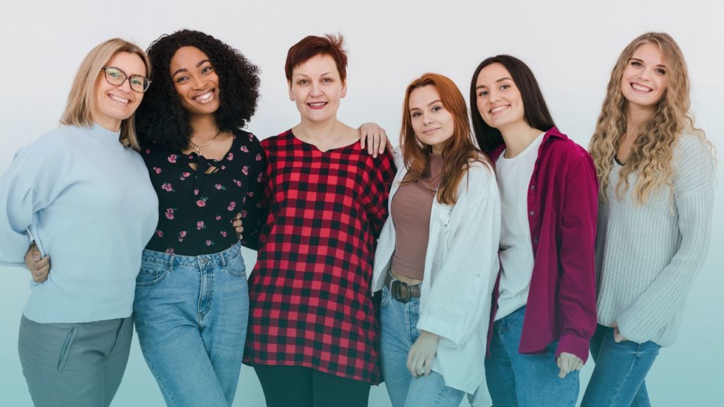 Seis mulheres posando para a foto. Imagem simboliza que são mulheres que trabalham na área de TI.